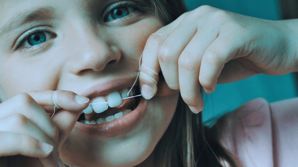 child flossing her teeth Creekside Dental