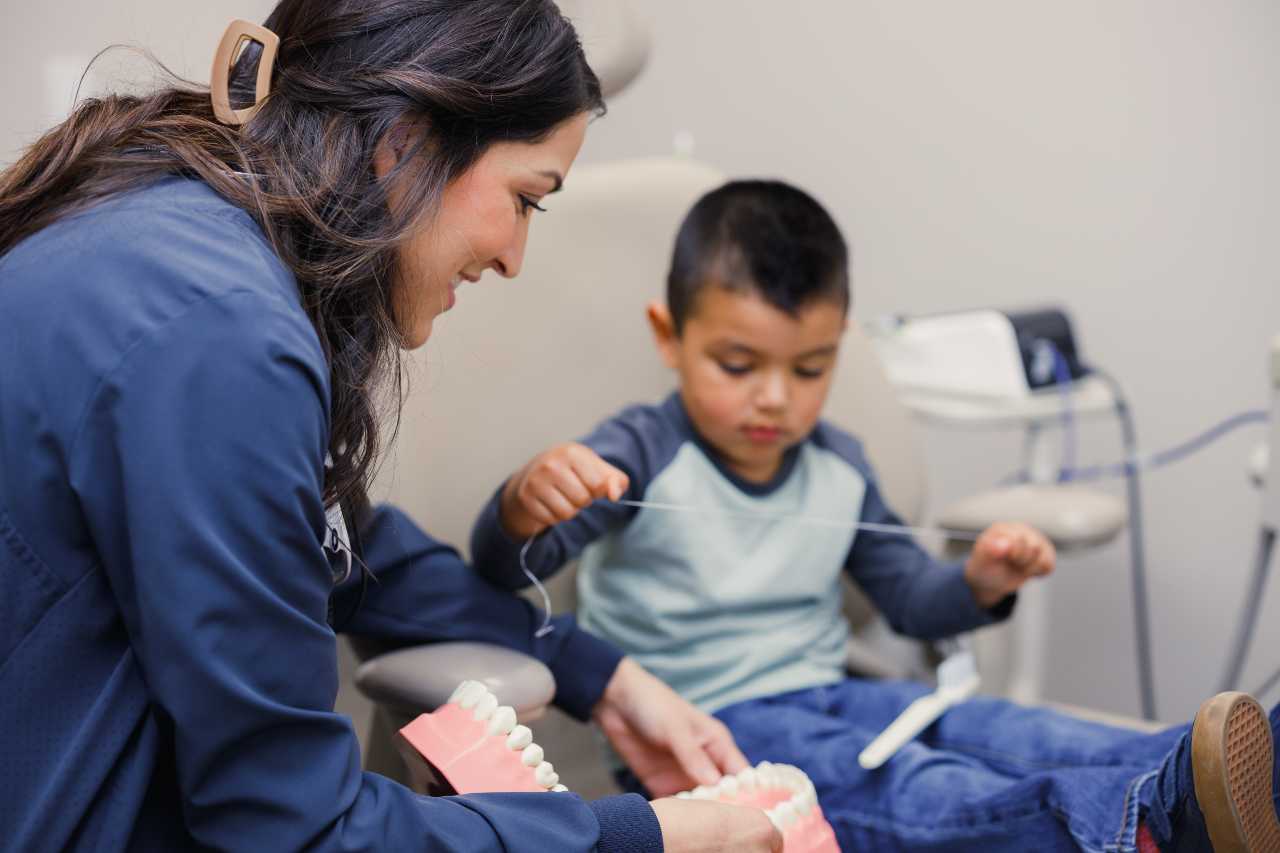kid flossing teeth with the dentist Creekside Dental