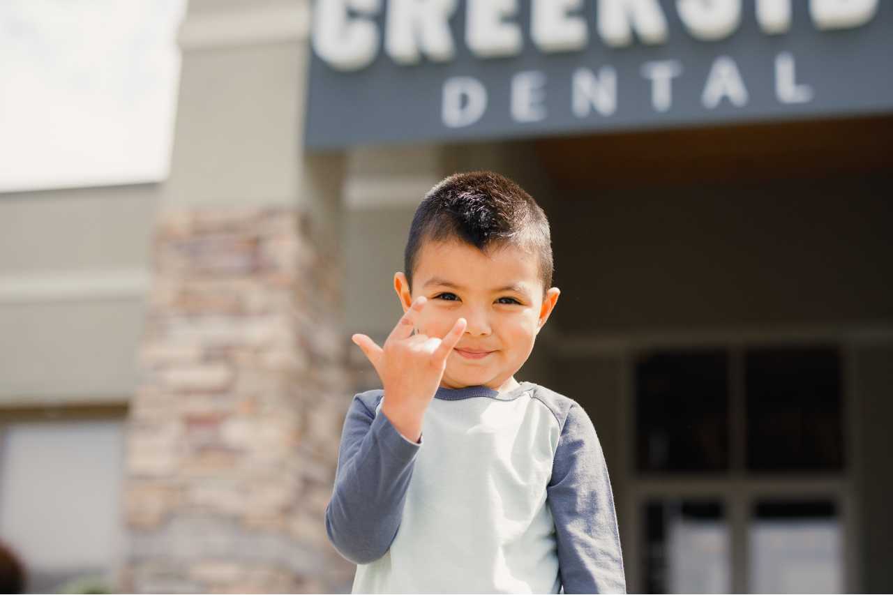 kid with the rock and roll hand sign Creekside Dental