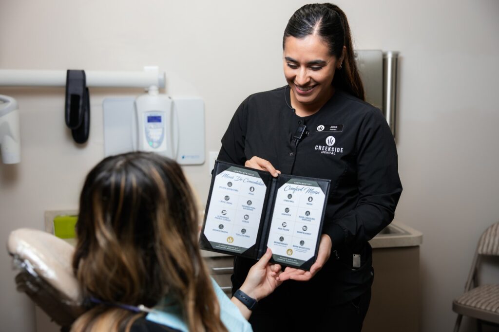 our Creekside Dental dentist showing our complimentary patient comfort menu to client