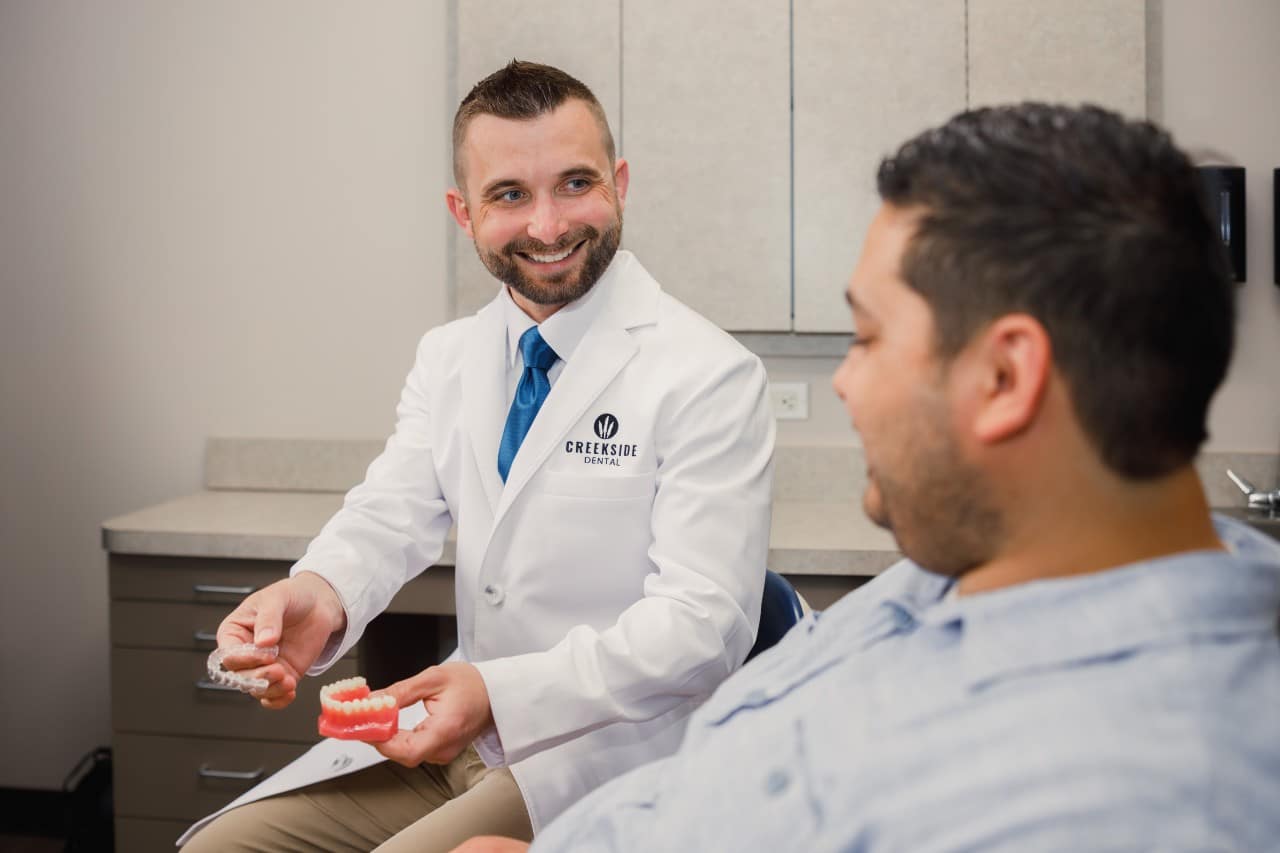 Dr. Bennett holding an Invisalign during a patient consultation