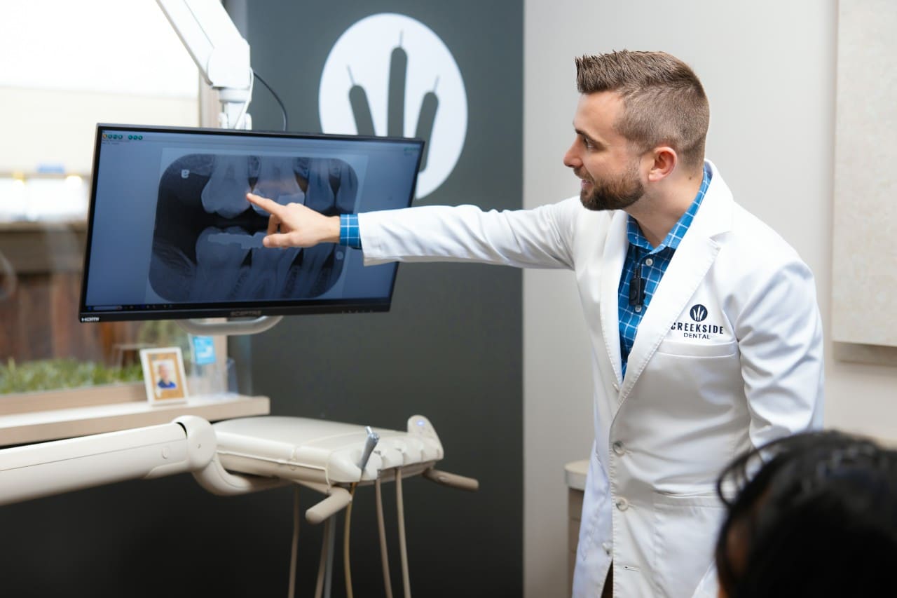 Dr. Bennett pointing at a digital x-ray with patient
